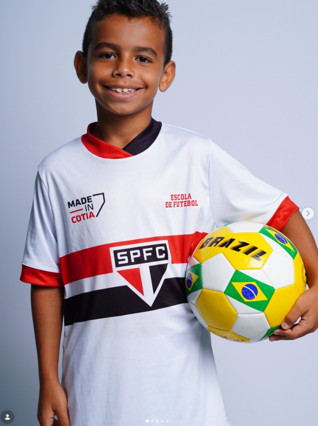 Treino com bola de futebol no gramado sob luzes do campo